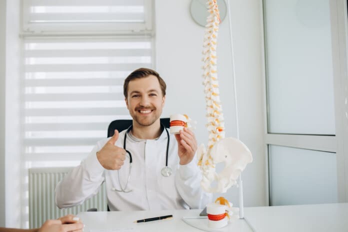 Portrait of male doctor physiotherapist in her workplace at hospital.