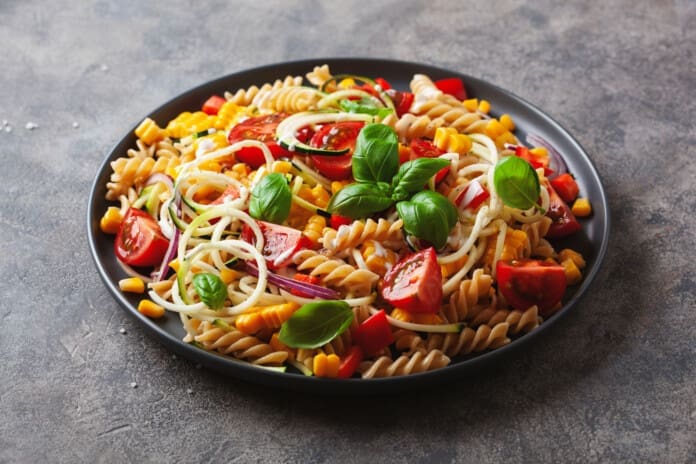 healthy pasta salad with zucchini sweet corn tomato and basil, v