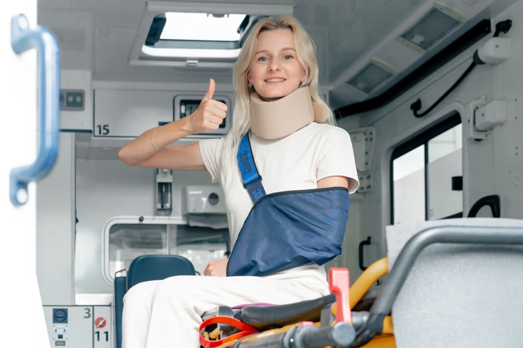 on the street in an ambulance a young patient with an injured neck and arm transporting the patient to the clinic first emergency aid