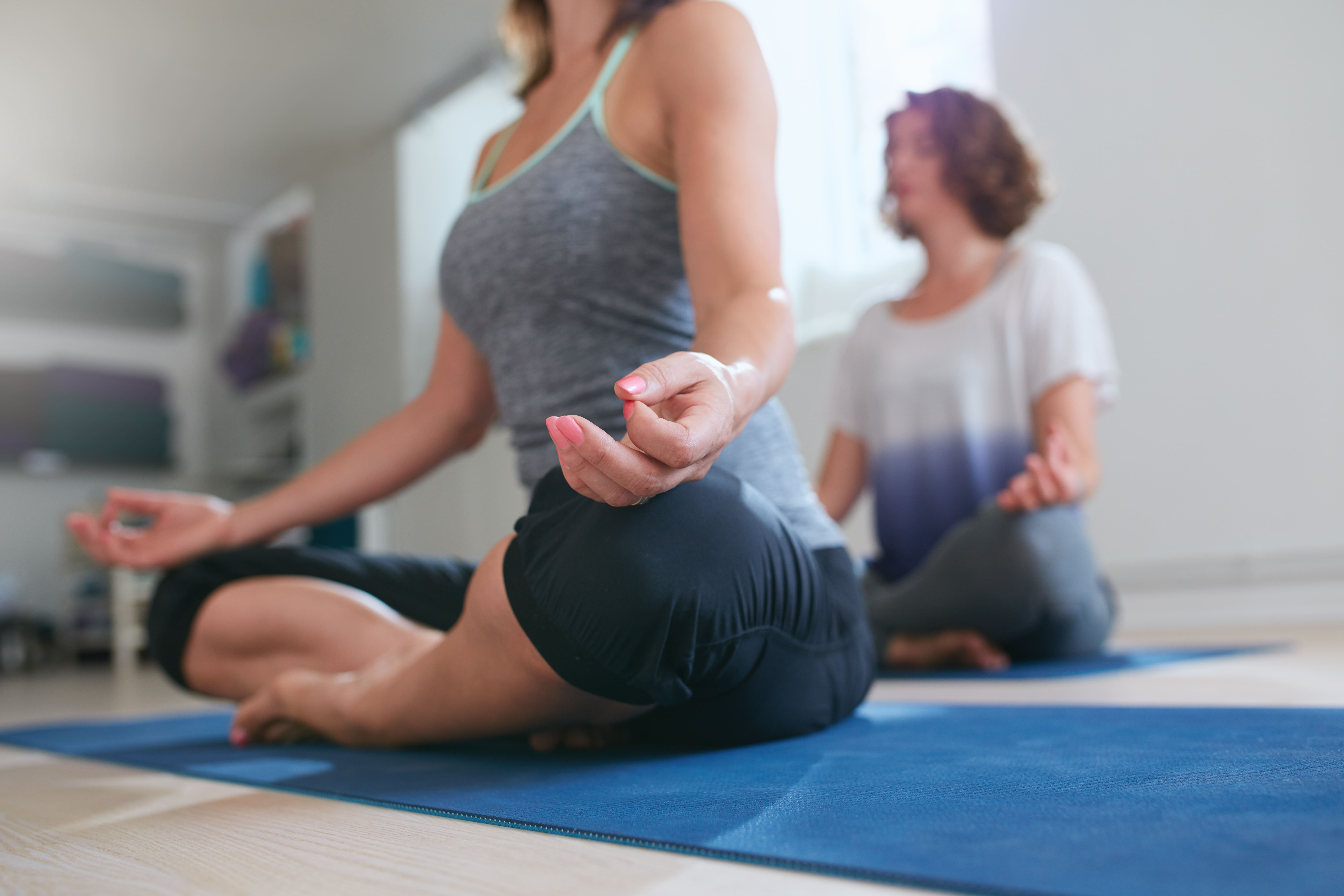 Female meditating in lotus pose at yoga class
