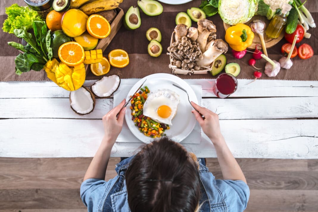 The woman at the dinner table with organic food , the view from the top.
