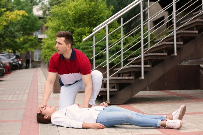Passerby helping woman with heart attack outdoors Slip-and-Fall Injuries: Steps to Take After an Accident