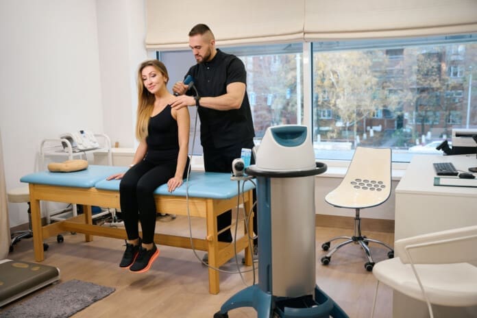 Woman at a shock wave therapy session Integrative Shockwave Therapy and Chiropractic Integration