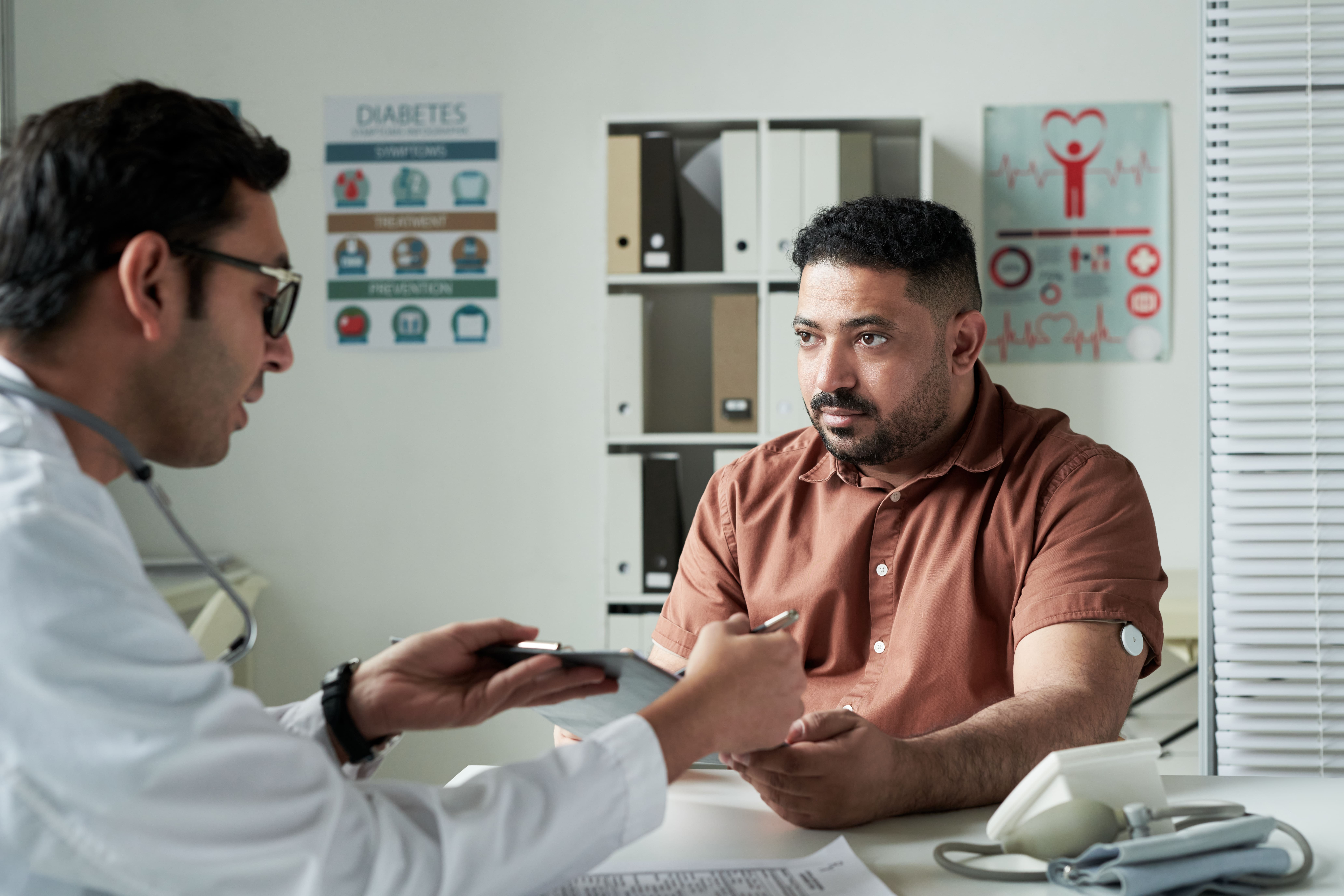 Middle Aged Caucasian Man Discussing Diabetes Care Plan with Male Doctor