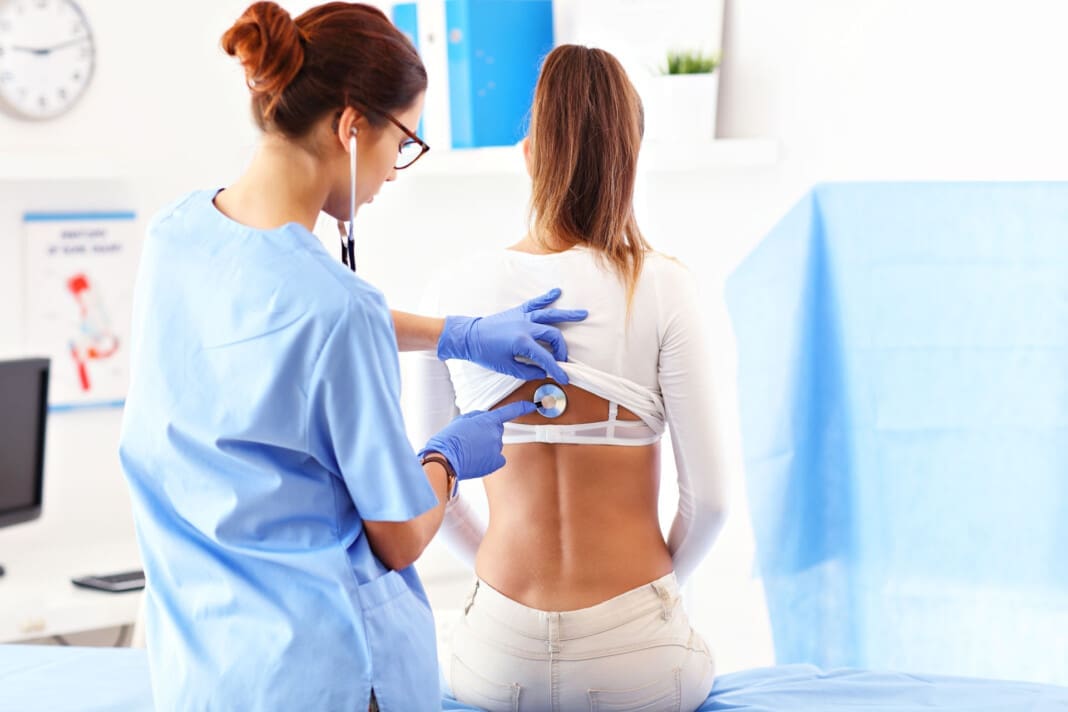 Adult woman being examined with stethoscope by female doctor