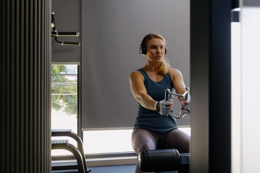 Focused female in gym engaged in rowing machine workout